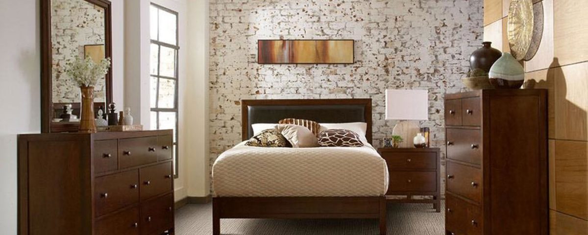 Cozy bedroom with floral wallpaper and wooden furniture.