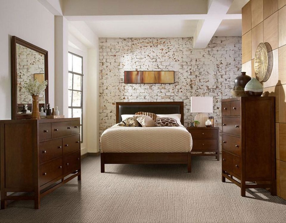 Cozy bedroom with floral wallpaper and wooden furniture.